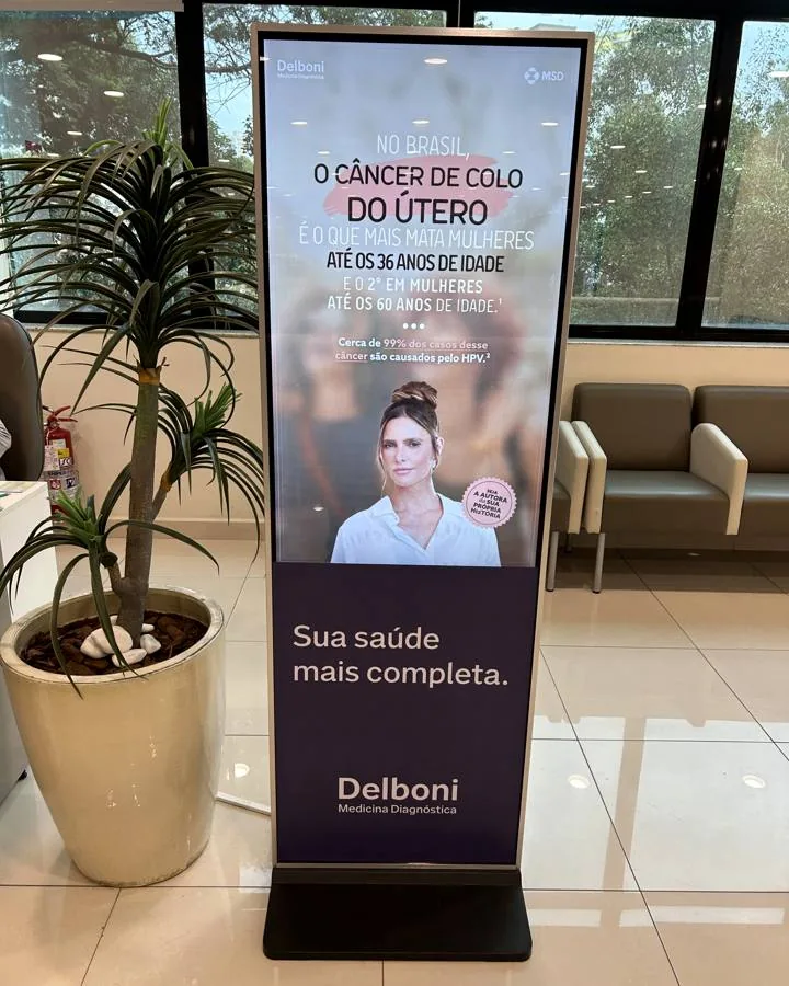 Totem digital Delboni em recepção com campanha de saúde na tela