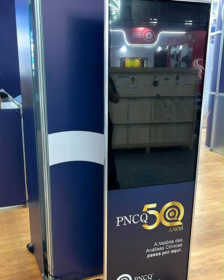 Totem digital PNCQ 50 anos em estande de feira de análises clínicas